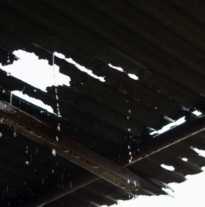 Rain pouring through a leaky tin roof