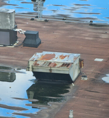 puddles on a commercial roof causing a leak