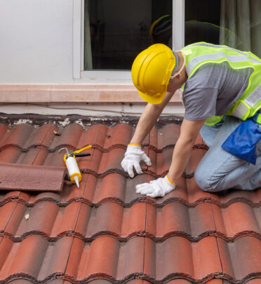man fixing a roof leak