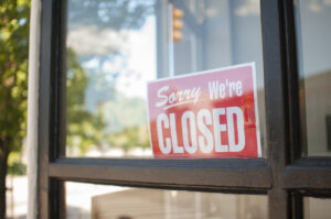 retail store with "closed" sign from disrupted operations after a roof leak