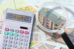 Cost of apartment roof replacement concept -  calculator saying "cost" and magnifying glass on an apartment roof building