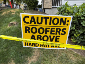 caution sign warning apartment building residents of roof work
